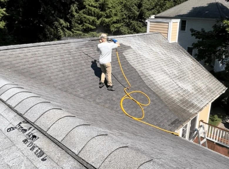 Strongsville Power Washing professional cleaning and inspecting gutters on Strongsville home